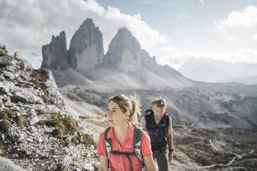 a man and a woman walking on a mountain at Hotel Alpenblick in Sesto