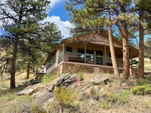 a house on top of a hill with trees at Rose Den - Romantic Mountain Cabin with Views! in Estes Park