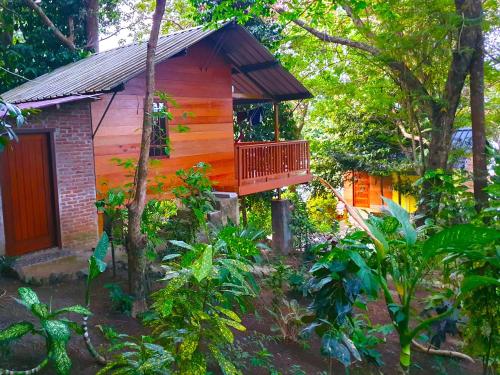 a wooden cabin in the middle of a forest at Santi Garden Bungalows in Iboih