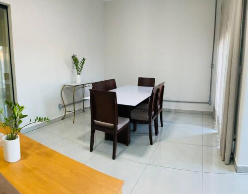 a dining room with a white table and chairs at Localizaçao privilegiada centro in Delfinópolis