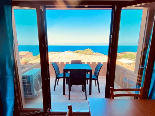 Una mesa y sillas en un balcón con vista al mar. en Costa Paradiso Villaggio maya GP 2 15 Bilocale vista mare, en Costa Paradiso