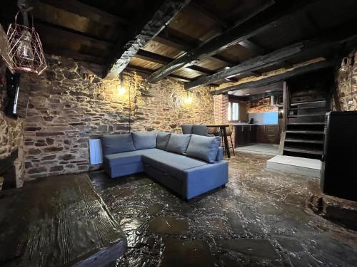 a living room with a blue couch in a brick wall at La Casina de Gelo in Riego de Ambros