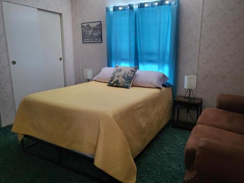 ScrantonにあるA rest after a day in the Death Valley desertのベッドルーム1室(青いカーテンとソファ付きのベッド1台付)