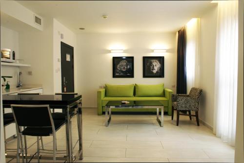 sala de estar con sofá verde y mesa en Best Western Regency Suites, en Tel Aviv