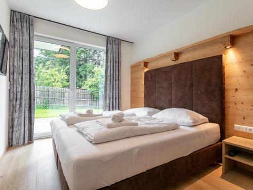a bedroom with two beds and a large window at Apart33 Top 2-1 in Haus im Ennstal