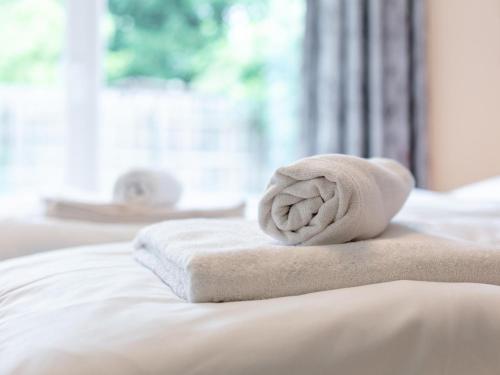 a stack of towels on a bed with a window at Apart33 Top 2-1 in Haus im Ennstal