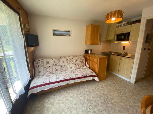 - une petite cuisine avec un lit dans une chambre dans l'établissement Appartement familial à 1 km du centre, proche télécabines et activités, multi Pass à 3€/jour - FR-1-693-99, à Châtel
