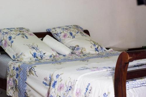 a bed with blue and white sheets and pillows at Pousada Brasil Paraty in Paraty