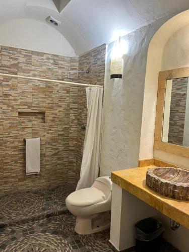 a bathroom with a toilet and a sink at Hotel Boutique Cantera in Querétaro