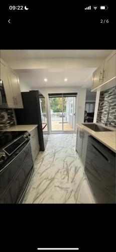 a large kitchen with marble floors and a large window at Le Rogers in Pointe-Calumet