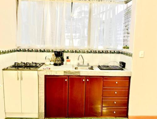 a kitchen with a sink and a stove and a window at Gaby's suite in Quito