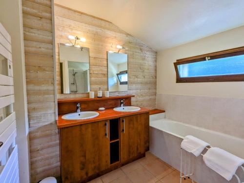 HaironvilleにあるMaison avec piscine chauffée, tennis gratuit, 5 chambres en bord de rivière - Haironville, France - FR-1-585-34の洗面台2つとバスタブ付きのバスルーム