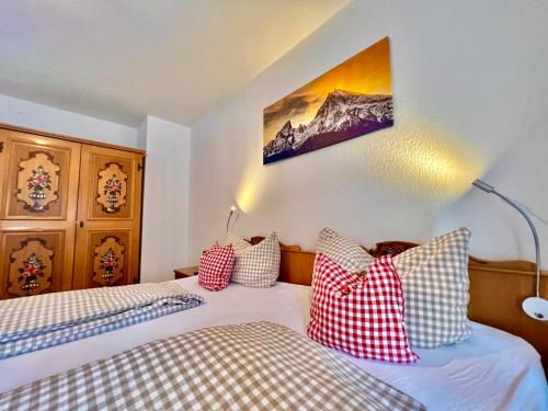 a bedroom with two beds and a picture on the wall at Ferienwohnungen Jagerer in Ramsau