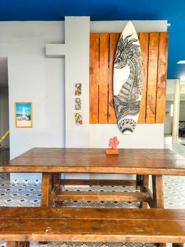 a wooden bench in front of a wall with a painting at Pousada Maresia Unique Beira Mar in Porto De Galinhas
