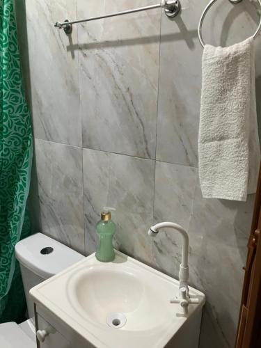 ein Badezimmer mit einem weißen Waschbecken und einer Toilette in der Unterkunft Casa de praia in Caraguatatuba