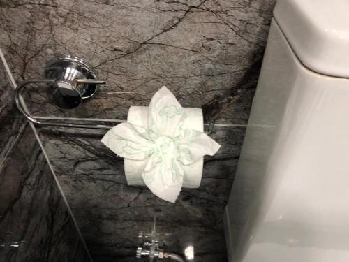 a toilet paper dispenser with a flower on a wall at Suite In City Center in Tirana