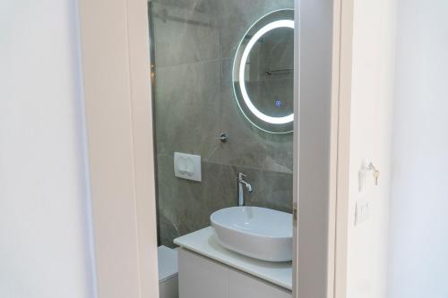 a bathroom with a white sink and a mirror at Koks’ Guesthouse in Himare