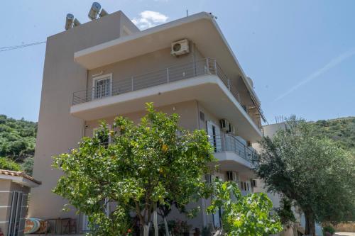 a white building with a tree in front of it at Koks’ Guesthouse in Himare