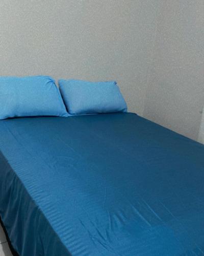 a blue bed with two pillows on top of it at Pousada Andrade in Parnaíba