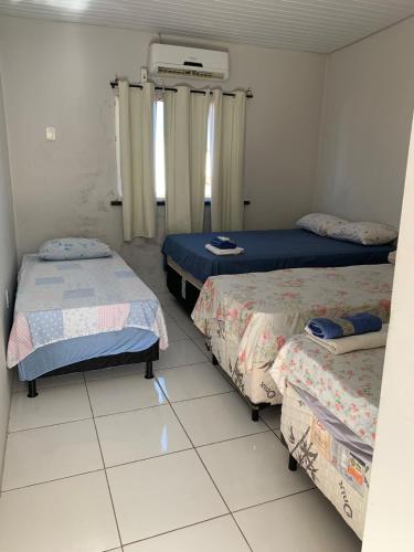 a room with three beds in a room at Pousada Andrade in Parnaíba