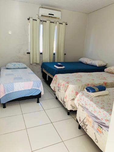 a room with three beds in a room at Pousada Andrade in Parnaíba