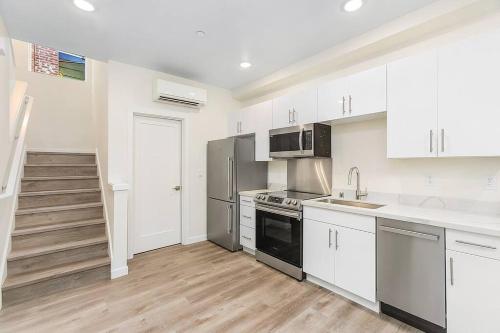 a kitchen with white cabinets and stainless steel appliances at Vermithor's Bronze Ember Sweet Suite in Seattle