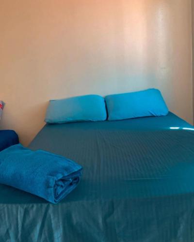 a blue bed with two blue pillows on it at Pousada Andrade in Parnaíba