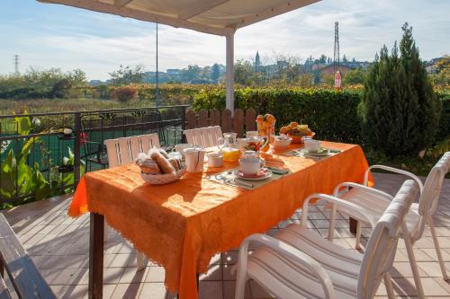 a table and chairs on a patio with an orange table cloth at B&B Villa Gloriana in Sona