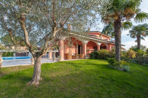 une maison avec deux palmiers dans une cour dans l'établissement B&B Villa Gloriana, à Sona