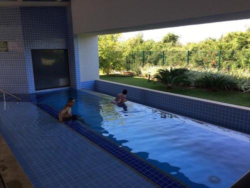 two children are sitting in a swimming pool at Alta Vista Thermas Resort in Caldas Novas