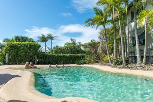 a group of people sitting in a swimming pool at The Retreat Beach Houses in Peregian Beach