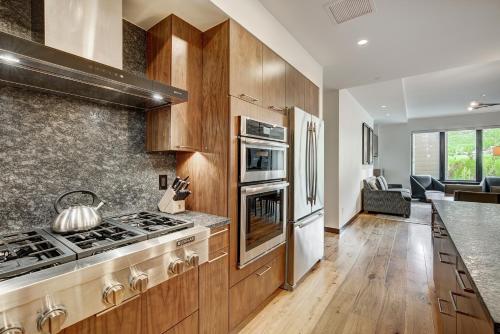 a kitchen with wooden cabinets and a stove top oven at The Arrabelle at Vail Square, a RockResort in Vail