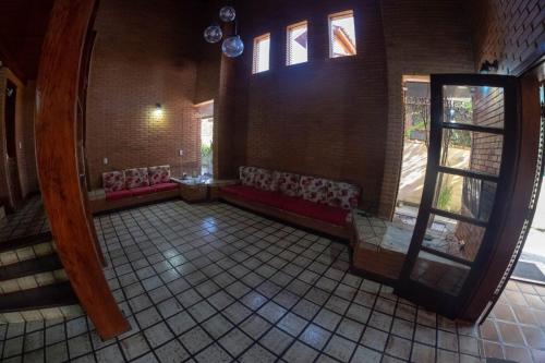 a room with couches and a window in a building at Hostel Trópico de Capricórnio - Tenório in Ubatuba