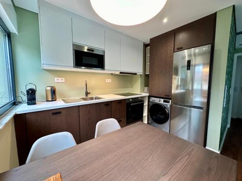 a kitchen with a wooden table and a refrigerator at House Real Companhia 55/53 in Vila Nova de Gaia