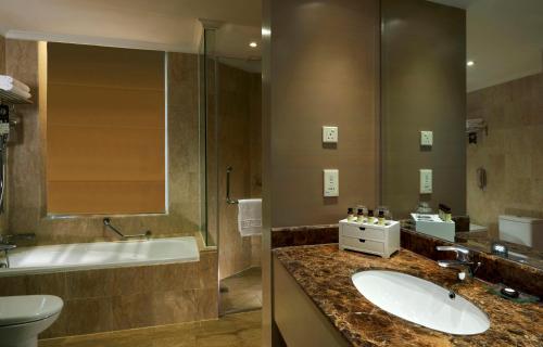 a bathroom with a sink and a tub and a toilet at Pullman Kuala Lumpur City Centre Hotel & Residences in Kuala Lumpur