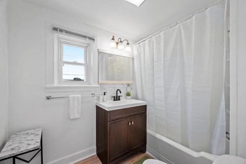a white bathroom with a sink and a shower at Slick&Spacious 2 Bdr Apt Natrona Hts in Natrona Heights
