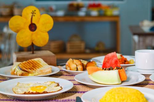 a table with plates of breakfast foods on it at Pousada Maresia Unique Beira Mar in Porto De Galinhas