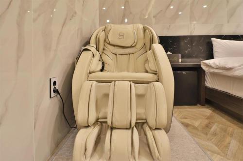 a white chair sitting in a room with a bed at Daegu Hotel Rubato in Daegu