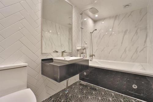 a white bathroom with a sink and a tub at Daegu Hotel Rubato in Daegu