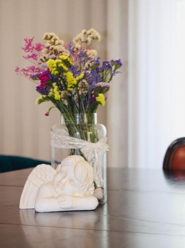 a vase with flowers and a statue on a table at The Oak´S Wolf-Country House in Fafe