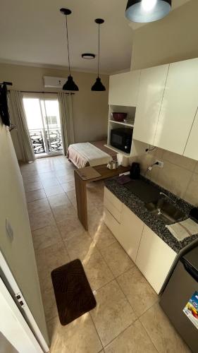 a kitchen with white cabinets and a room with a bed at Temporario en Reconquista Centro in Reconquista