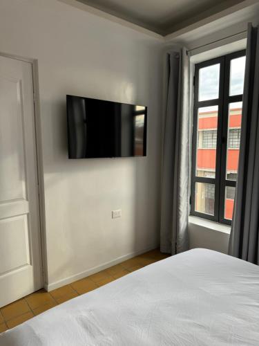 Una televisión o centro de entretenimiento en Hotel Mado
