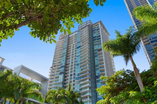 a tall building with palm trees in the foreground at Brighton Shores in Gold Coast