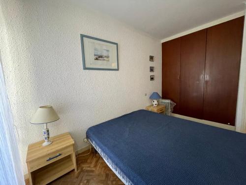 - une chambre avec un lit bleu et des placards en bois dans l'établissement T2 avec WIFI, parking, loggia et vue mer à Banyuls-sur-Mer - FR-1-309-318, à Banyuls-sur-Mer