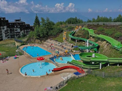 un grand parc aquatique avec deux piscines et toboggans dans l'établissement Charmant studio rénové au cœur de Prapoutel - FR-1-771-26, à Les Adrets