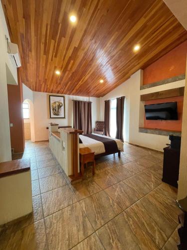 a bedroom with a bed and a wooden ceiling at Hotel & Balneario Los Angeles in Taxco de Alarcón