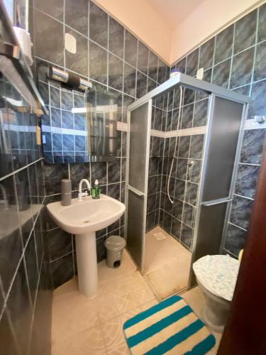 a small bathroom with a sink and a shower at Apto Salinas in Salinópolis