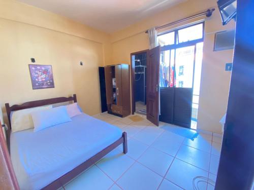 a bedroom with a bed and a large window at Apto Salinas in Salinópolis