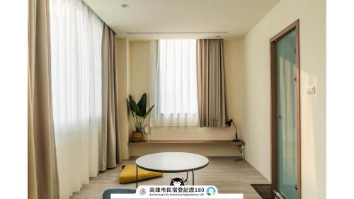 un soggiorno con un tavolo e una finestra di Yi Hostel a Kaohsiung