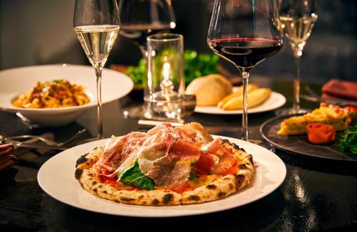a table with plates of food and glasses of wine at Park Hotel Tokyo in Tokyo